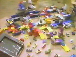 The Stop-Motion Army attacks GDW's foot. Note Decepticon Skyhopper and Skystalker's battle stations connected to the Micro-City. 